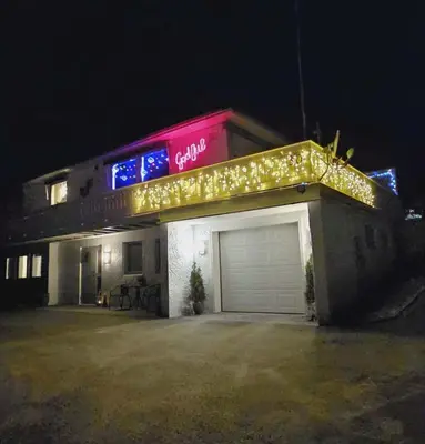 a lit up building with a garage at night at Gjesterom til leie i et privat hus in Brumunddalen