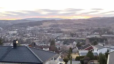 a city with houses and mountains in the distance at Gjesterom til leie i et privat hus in Brumunddalen