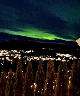 a view of a city at night with green lights at Gjesterom til leie i et privat hus in Brumunddalen