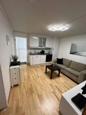 a living room with a couch and a kitchen at Apartment in Åsane in Bergen