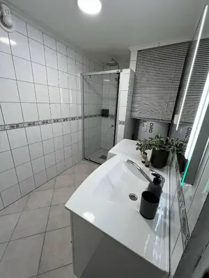 a bathroom with a white sink and a shower at Apartment in Åsane in Bergen