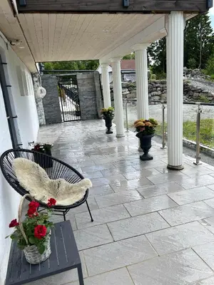 a porch with a bench and flowers on it at Apartment in Åsane in Bergen