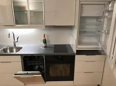 a kitchen with a sink and an open refrigerator at Apartment in Åsane in Bergen