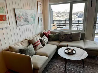 a living room with a couch and a table at Skarsnuten Panorama 46 in Hemsedal