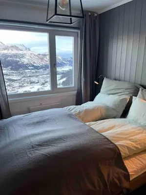 a bedroom with a bed and a large window at Skarsnuten Panorama 46 in Hemsedal