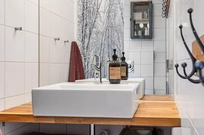 a white bathroom sink with a bottle of wine on it at Skarsnuten Panorama 46 in Hemsedal