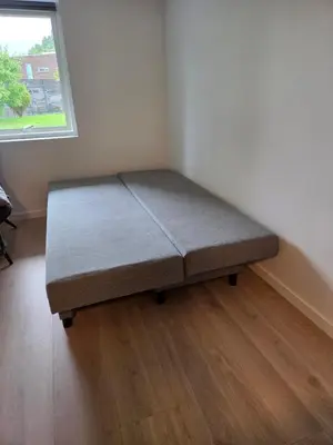 a bed in a corner of a room with a window at Near Bergen City, Apartment 7 min from the airport, free parking in Bergen