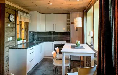 a kitchen with white cabinets and a table with chairs at Cozy Apartment In Gol With Wifi in Gol
