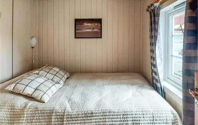a bed in a corner of a room with a window at Cozy Home In Mosvik With House Sea View in Mosvik