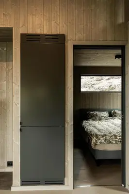 a small bedroom with a bed and a door to a closet at Moderne hytte på Norefjell in Noresund
