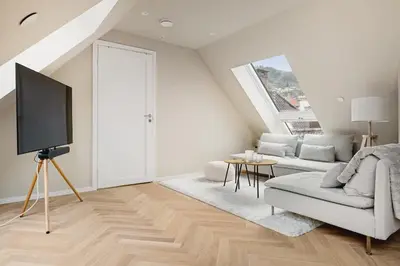 a living room with a couch and a tv at Dinbnb Apartments I Mid-City Luxury with Mini Balcony and Smart TV & Sound System in Bergen