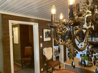 a living room with a chandelier in a room at Lun og koselig hytte med sauna på Filefjell in Tyinkrysset