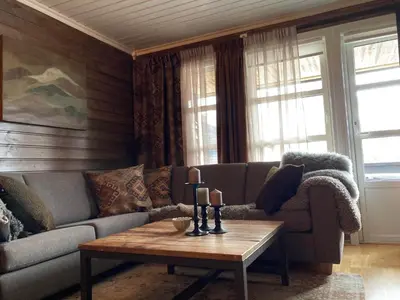 a living room with a couch and a coffee table at Lun og koselig hytte med sauna på Filefjell in Tyinkrysset