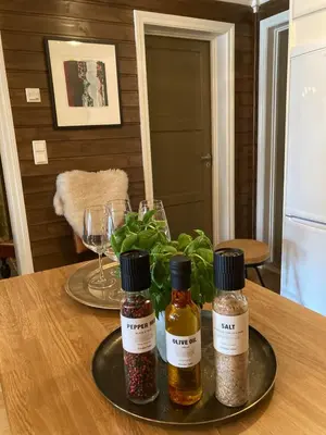 a table with two bottles of spices on a plate at Lun og koselig hytte med sauna på Filefjell in Tyinkrysset