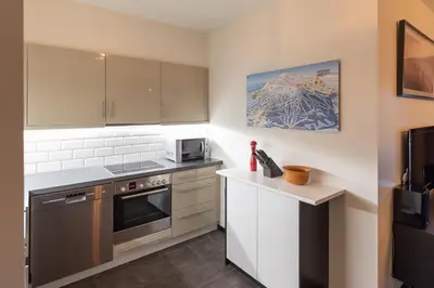 a kitchen with stainless steel appliances and white cabinets at Høyfjellsgrend 961, 29 B in Trysil
