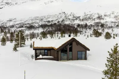 a cabin in the snow with a mountain at Tonningssætra Mountain Lodge in Stryn
