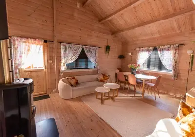 a living room with a couch and a table at Cabin near the lake in Årset