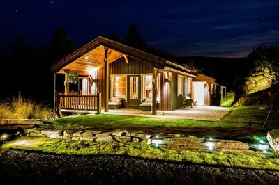 a house at night with a pond in front of it at Luxury cabin in the mountains with all facileties in Sønstebø