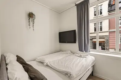 a bedroom with a bed and a tv on the wall at Family Friendly - Modern - City Central in Bergen