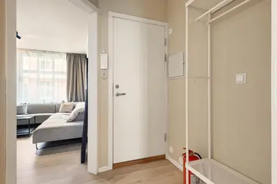 a living room with a couch and a sliding door at Family Friendly - Modern - City Central in Bergen