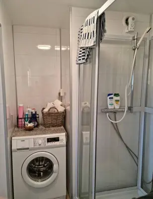 a washing machine in a bathroom with a shower at Apartment near center / free P in Ålesund