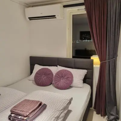 a bedroom with a bed with purple pillows on it at Apartment near center / free P in Ålesund