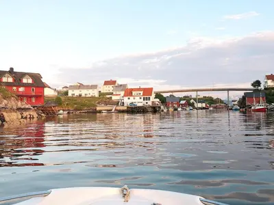 a boat in a body of water with houses and a bridge at 8 person holiday home in averøy-By Traum in Averoy