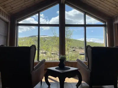 a room with two chairs and a table in front of a window at Hjemmekoselig hytte på Rauland in Rauland