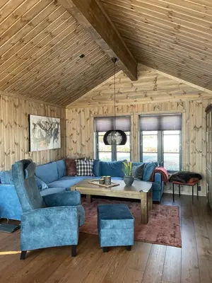 a living room with a blue couch and a table at Hjemmekoselig hytte på Rauland in Rauland
