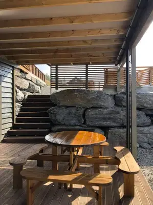 a table and two benches on a wooden deck at Bordalen-Voss in Rjoo