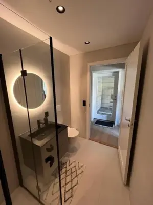 a bathroom with a sink and a toilet and a mirror at Studio Leiligheit in Sogndal