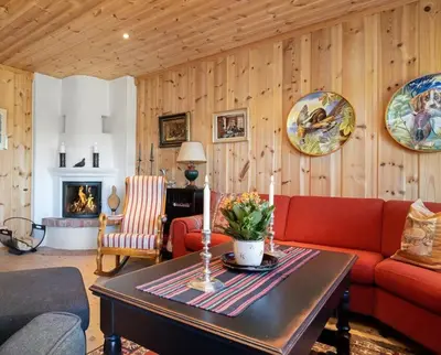a living room with a red couch and a table at Leilighet sentralt på Beitostølen in Beitostøl