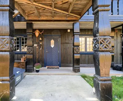 a house with a blue door and a wooden ceiling at Leilighet sentralt på Beitostølen in Beitostøl