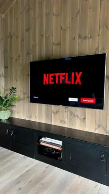 a flat screen tv sitting on top of a wooden wall at Luxurious 5-Bedroom Mountain Chalet with Sauna, Panoramic Views, and Two Full Bathrooms in Stranda