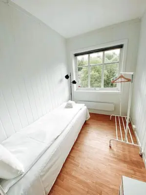 a white room with a bed and a window at Trolltunga Sleep in Tveit