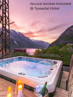 a hot tub with a view of the mountains at Trolltunga Sleep in Tveit