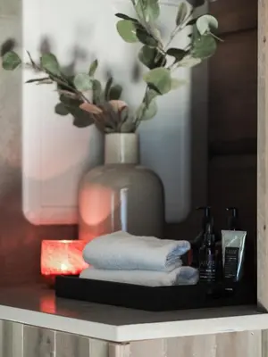 a shelf with a vase and a pile of towels at Dream Cabin Mivo X - Mountain Views and Idyllic Location at Strandafjellet in Stranda
