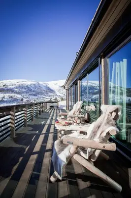 a row of lounge chairs on the deck of a building at Dream Cabin Mivo X - Mountain Views and Idyllic Location at Strandafjellet in Stranda