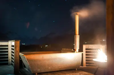 a bath tub sitting on a deck with a factory at Dream Cabin Mivo X - Mountain Views and Idyllic Location at Strandafjellet in Stranda
