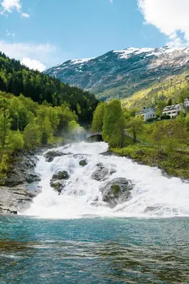 a waterfall on a river in the mountains at Dream Cabin Mivo X - Mountain Views and Idyllic Location at Strandafjellet in Stranda