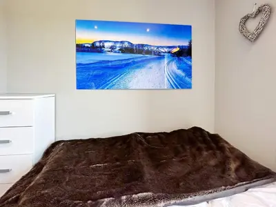 a bedroom with a bed with a blanket and a picture on the wall at 4 person holiday home in GEILO-By Traum in Geilo