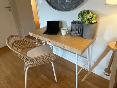 a wooden desk with a laptop and a chair at Apartments Bergen with sea view! in Bergen