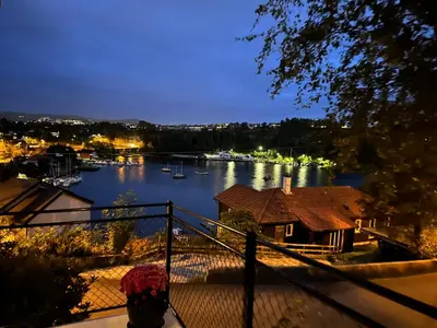 a view of a river at night from a balcony at Apartments Bergen with sea view! in Bergen