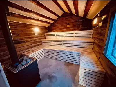 an empty sauna in a wooden cabin with a window at Traditional barn -Stabbur - wifi og sauna in Baukål