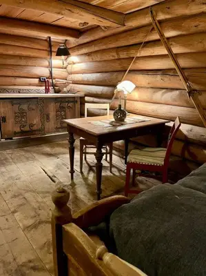 a wooden room with a table and a bed at Traditional barn -Stabbur - wifi og sauna in Baukål