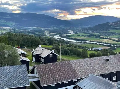 a view of a village with mountains in the background at Traditional barn -Stabbur - wifi og sauna in Baukål