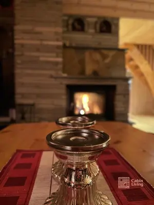 a candle holder on a table in front of a fireplace at Large cabin with Sjusjøens best view, sauna and ski in out in Ringsaker
