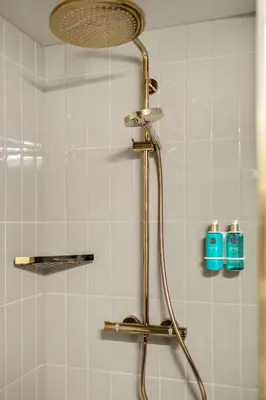 a shower with a shower head in a bathroom at Biologen Herdla in Askøy