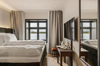 a hotel room with two beds and a window at Biologen Herdla in Askøy