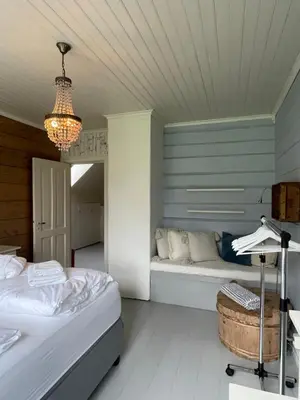 a bedroom with two beds and a bench and a chandelier at Monshaugen Home - Privat Retreat in Sykkylven
